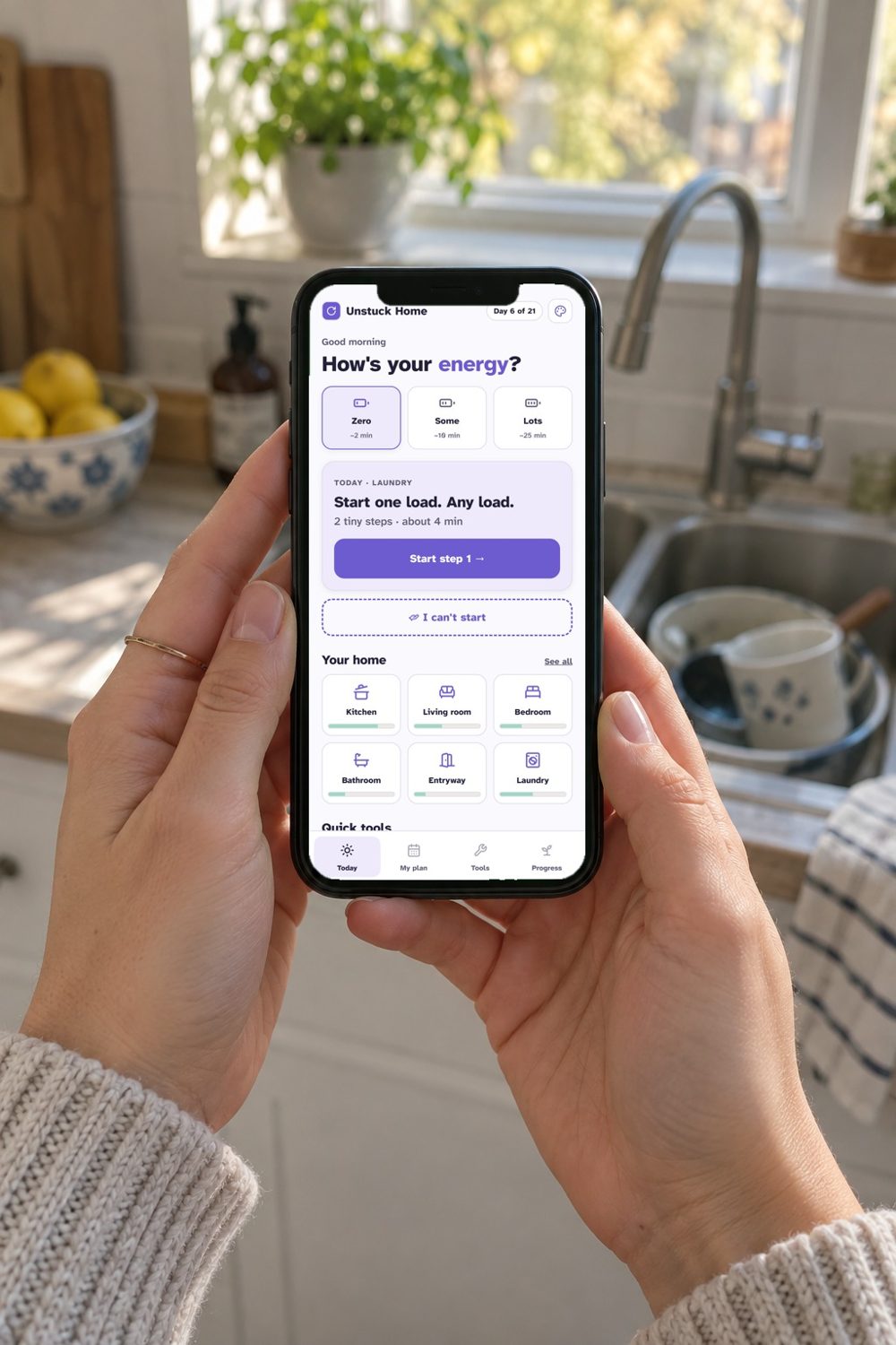 Hands holding a phone with the Unstuck Home app open in a kitchen